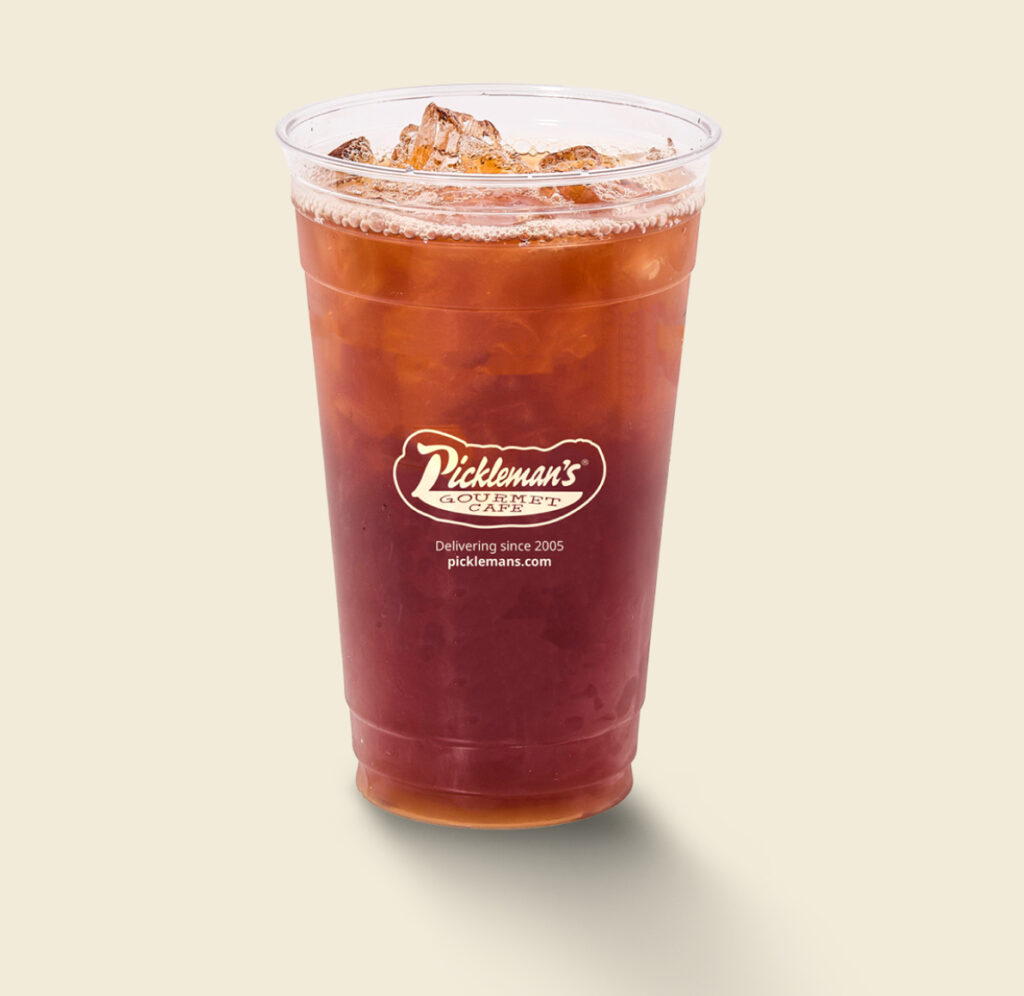 A clear Pickleman’s branded cup filled with iced tea and ice cubes on a light background.